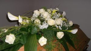 Sarggebinde mit Rosen und Calla Pflanzen