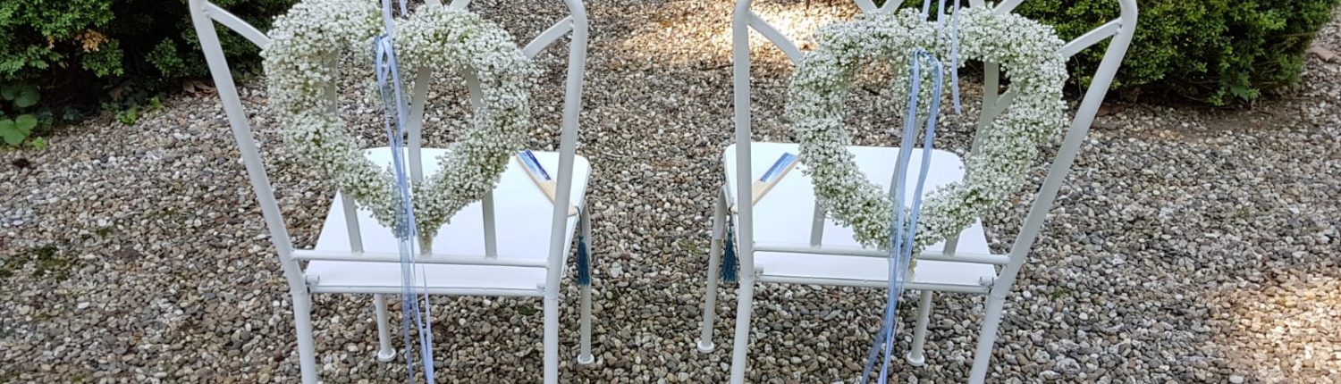 Liebevoll geschmückte Stühle für das Brautpaar einer Sommerhochzeit von BlumenGarten Marquardt